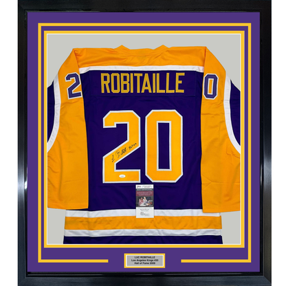 Framed Los Angeles Kings purple and gold #20 hockey jersey signed by Luc Robitaille, displayed front-facing with authentication certificates visible.