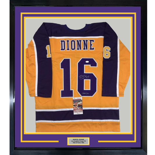 Framed orange and navy Los Angeles Kings hockey jersey #16 with "DIONNE" nameplate, signed, displayed flat against purple and gold matting with authentication certificate.