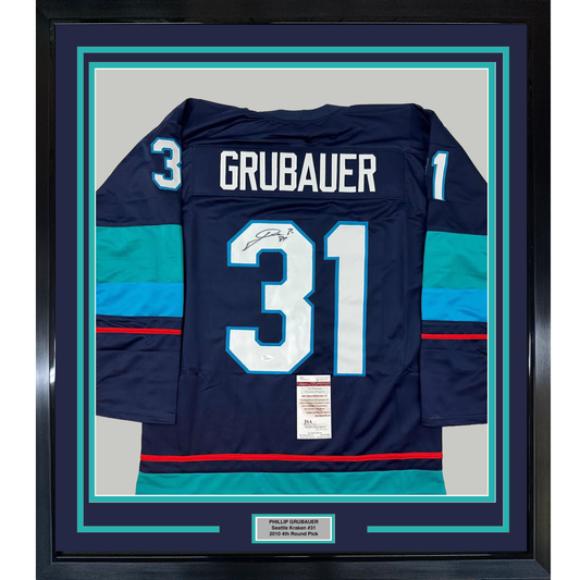 Framed navy Seattle Kraken hockey jersey #31 signed by Grubauer, displayed flat with turquoise matting and authentication certificate visible.