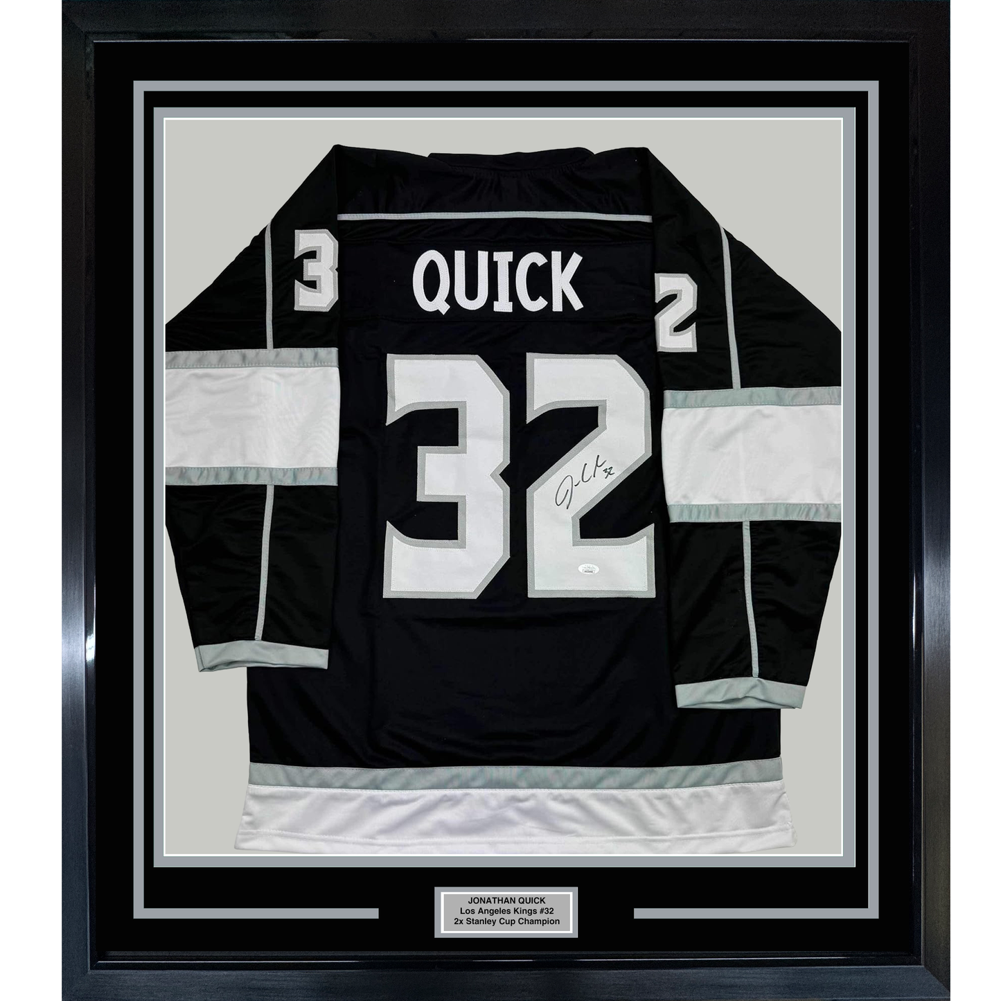 Framed black Los Angeles Kings hockey jersey #32 with "QUICK" nameplate and autographed number, displayed flat against white matting in black frame.