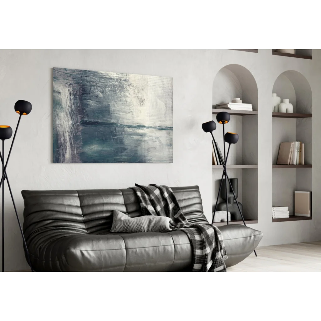 Black leather couch with plaid throw and textured blue gray abstract wall art