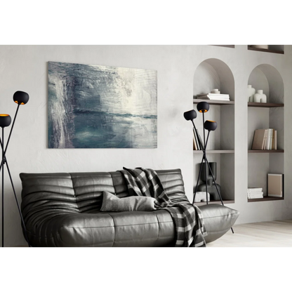 Black leather couch with plaid throw and textured blue gray abstract wall art