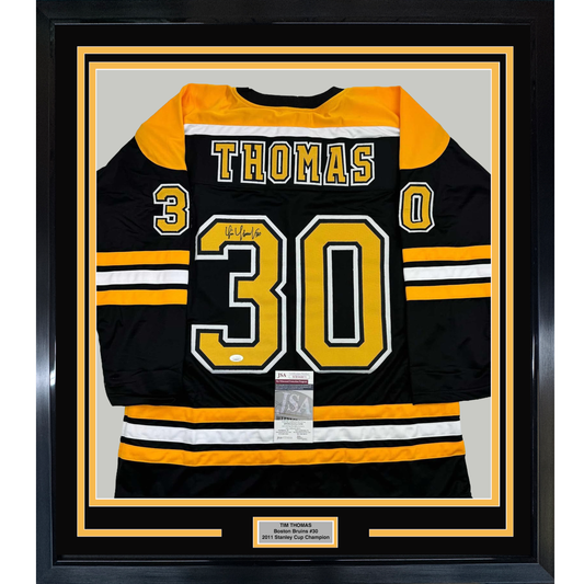 Framed black and gold Boston Bruins hockey jersey number 30 with "THOMAS" nameplate and signature, displayed flat against gray background with authentication certificate visible.