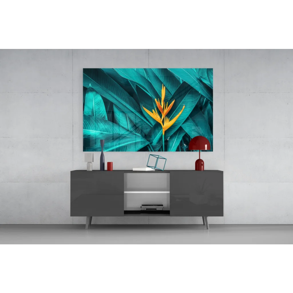 Vibrant teal and yellow bird of paradise glass wall art above gray console