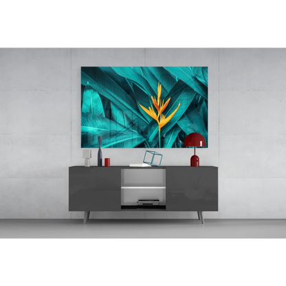 Vibrant teal and yellow bird of paradise glass wall art above gray console