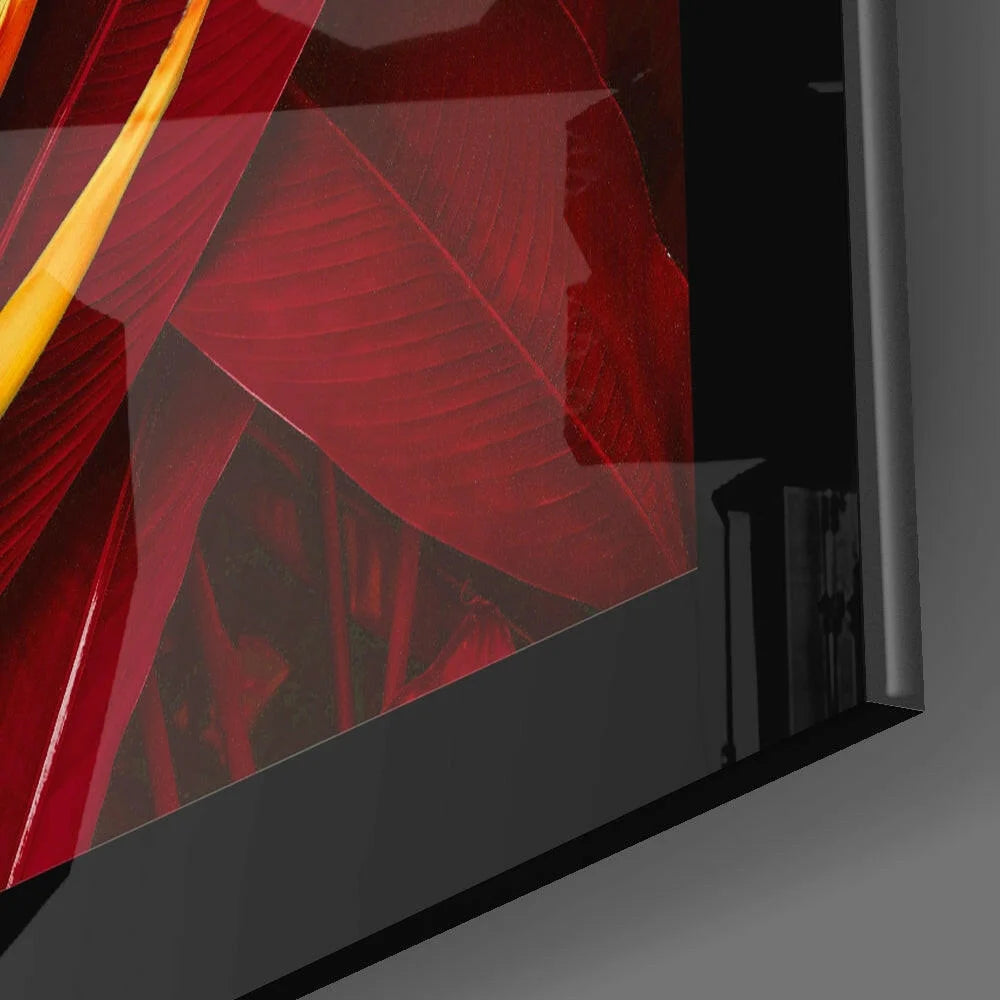 Glossy black-framed glass wall art with vibrant red and yellow abstract leaf patterns