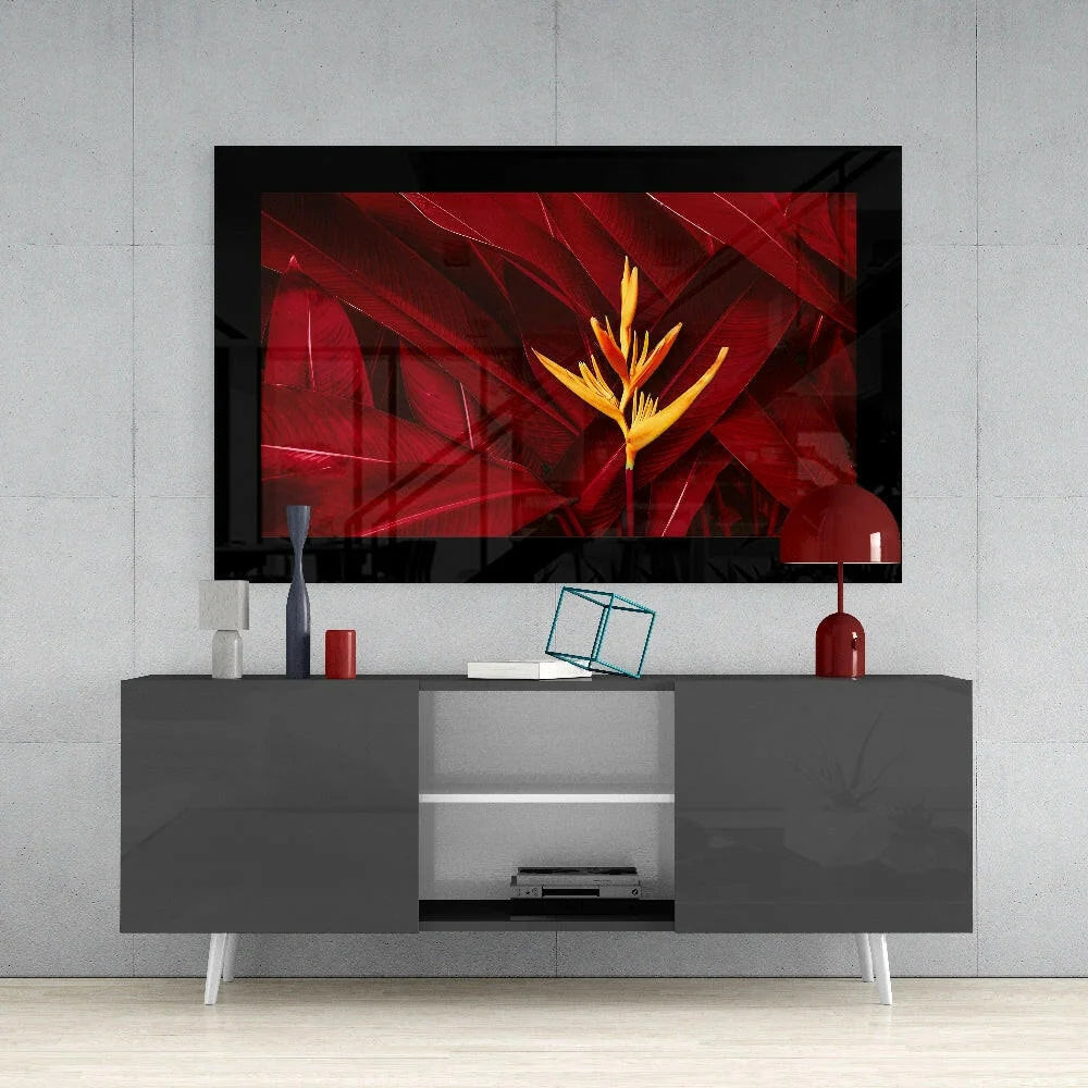 Striking red and yellow bird of paradise glass wall art in black frame