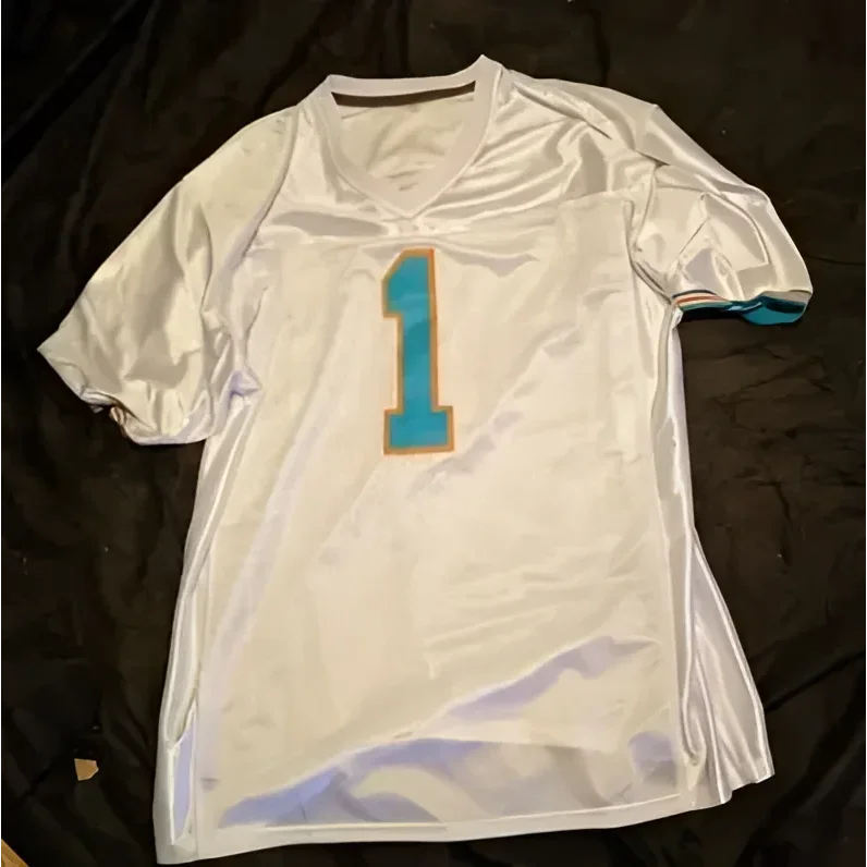 White Tua Tagovailoa Miami Dolphins autographed jersey with teal number 1 outlined in orange
