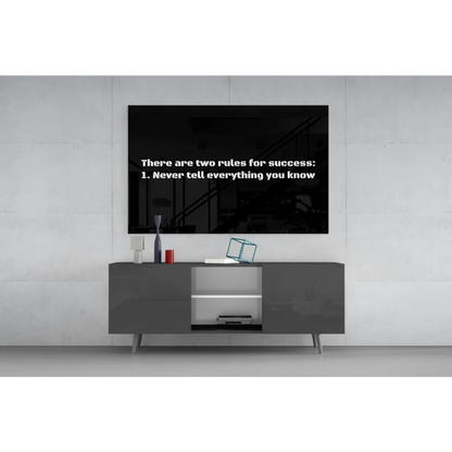Black framed TV showing Success Rules on dark screen, black wall art