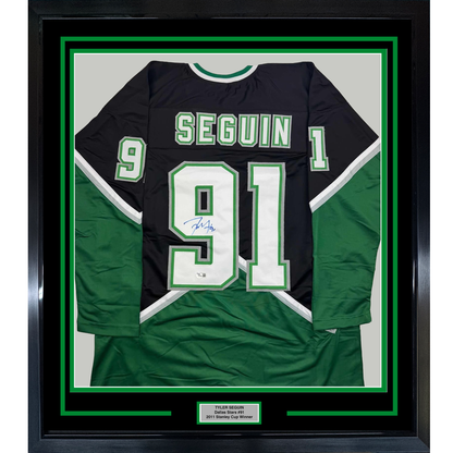 Framed black and green Dallas Stars hockey jersey #91 signed by Tyler Seguin, displayed flat with nameplate below.