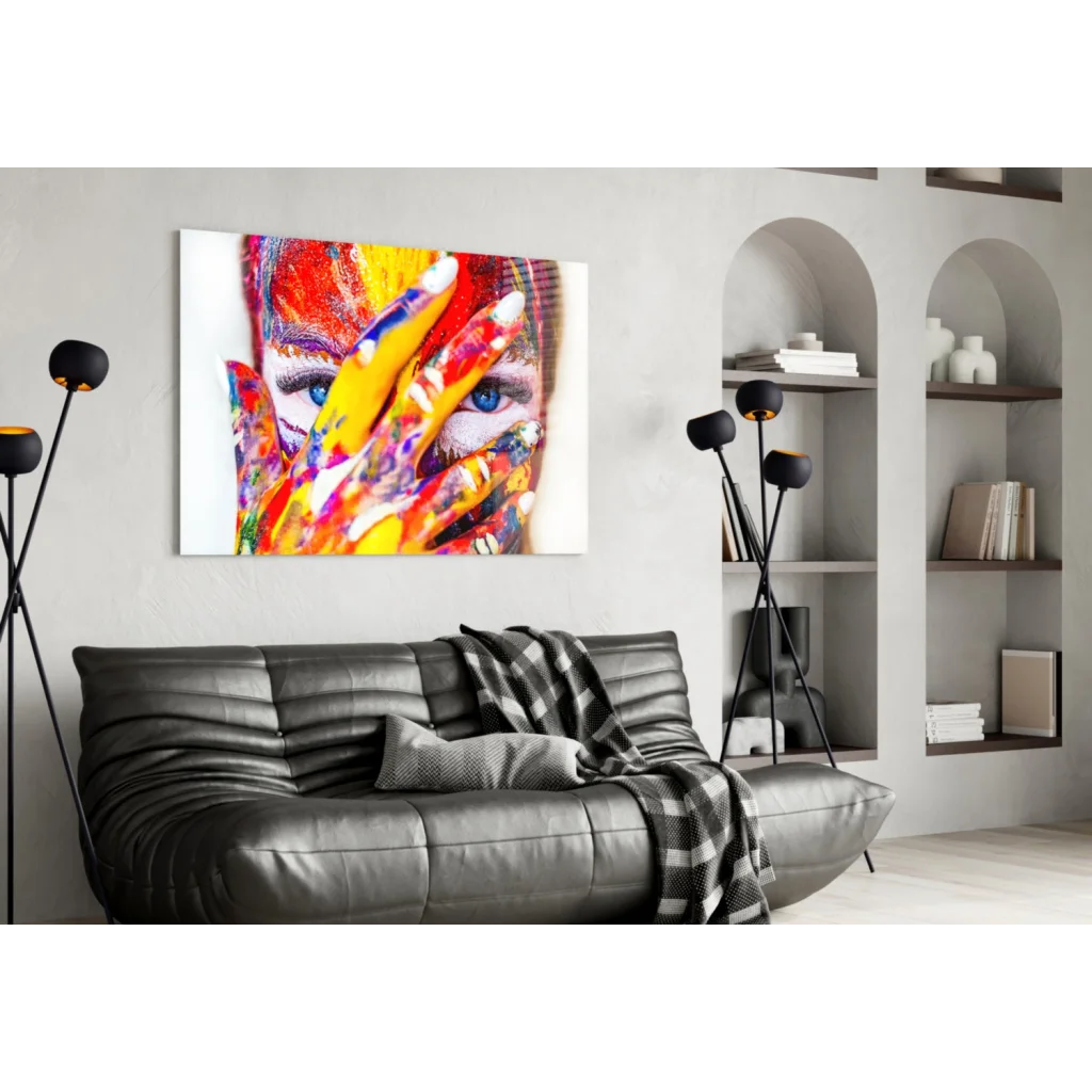 Vibrant abstract face wall art with colorful handprints on black leather couch