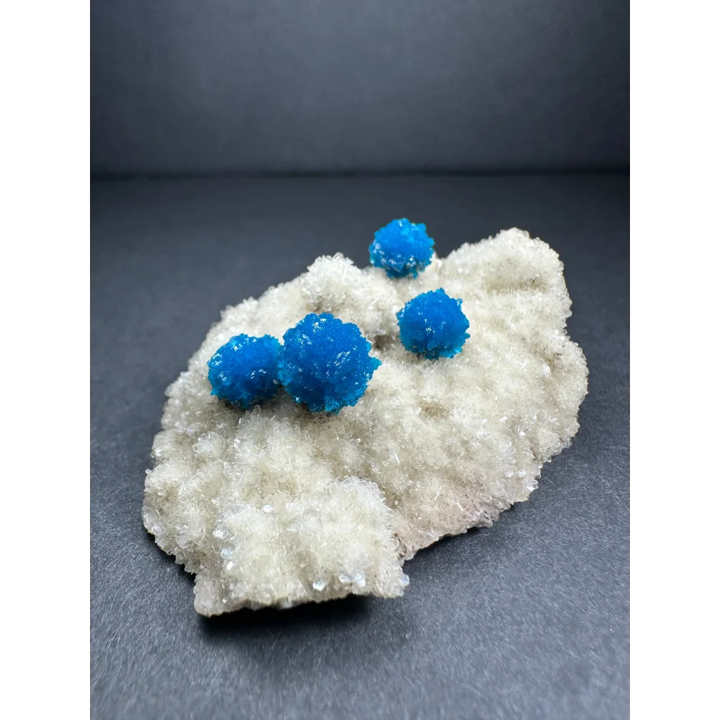 Vibrant blue cavansite balls on white stilbite matrix from India