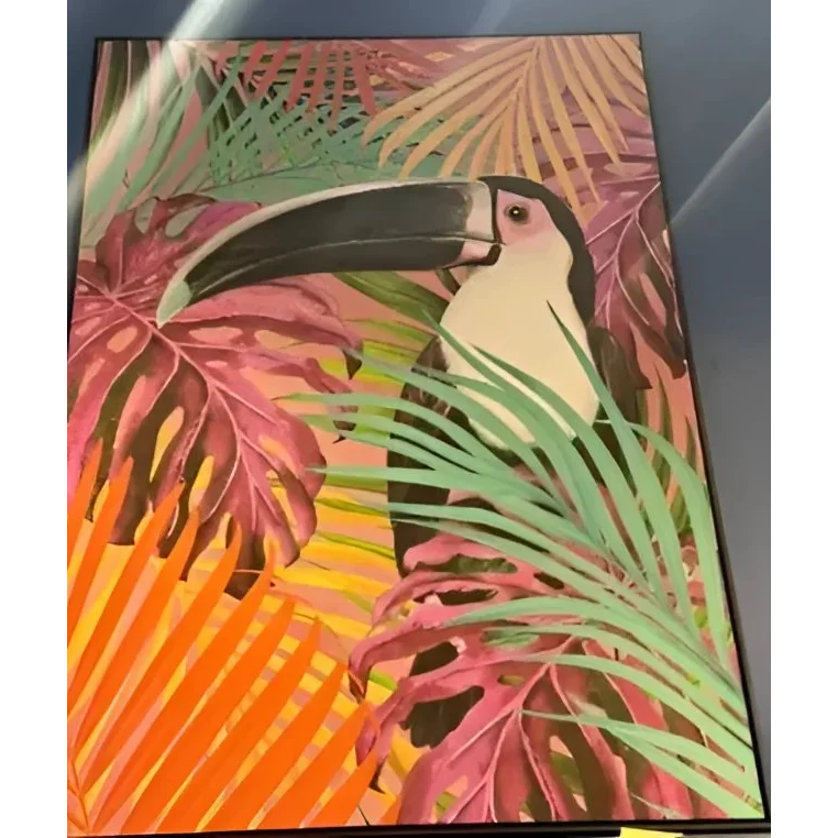 Colorful framed art print of a fluo toucan framed with tropical foliage for vibrant decor