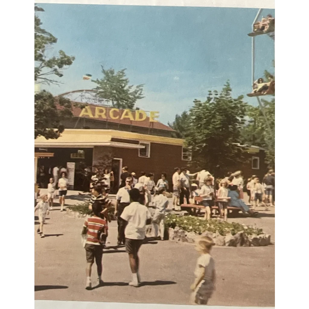 Arcade building at Canobie Lake Park with yellow sign, bustling with people and trees