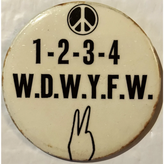 Circular button features peace symbol and hand gesture, celebrating 1960s Vietnam War protest