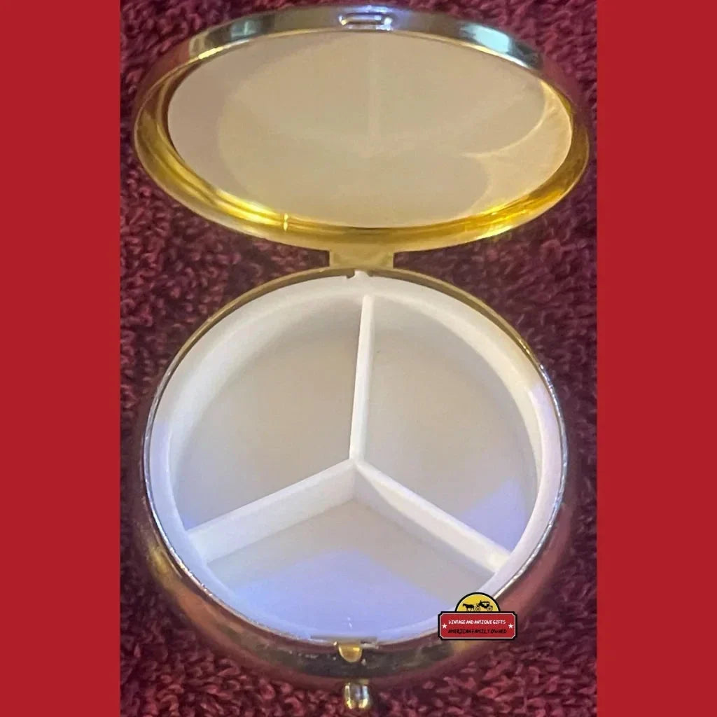 Circular gold-rimmed compact with three compartments, a vintage 1970s cameo piece