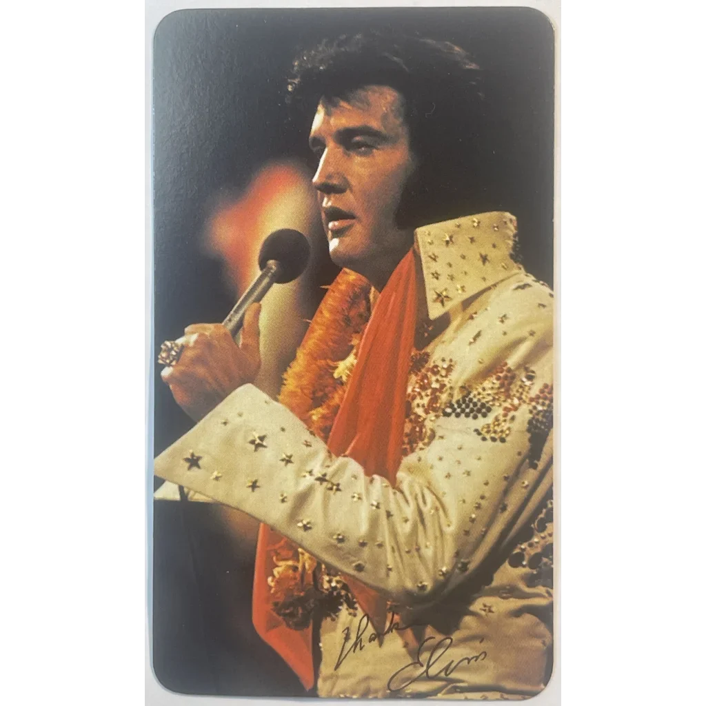 Performer in a white rhinestone jumpsuit singing for the Elvis Presley Card Calendar