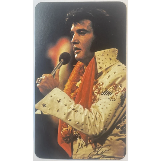 Performer in a white rhinestone jumpsuit singing for the Elvis Presley Card Calendar