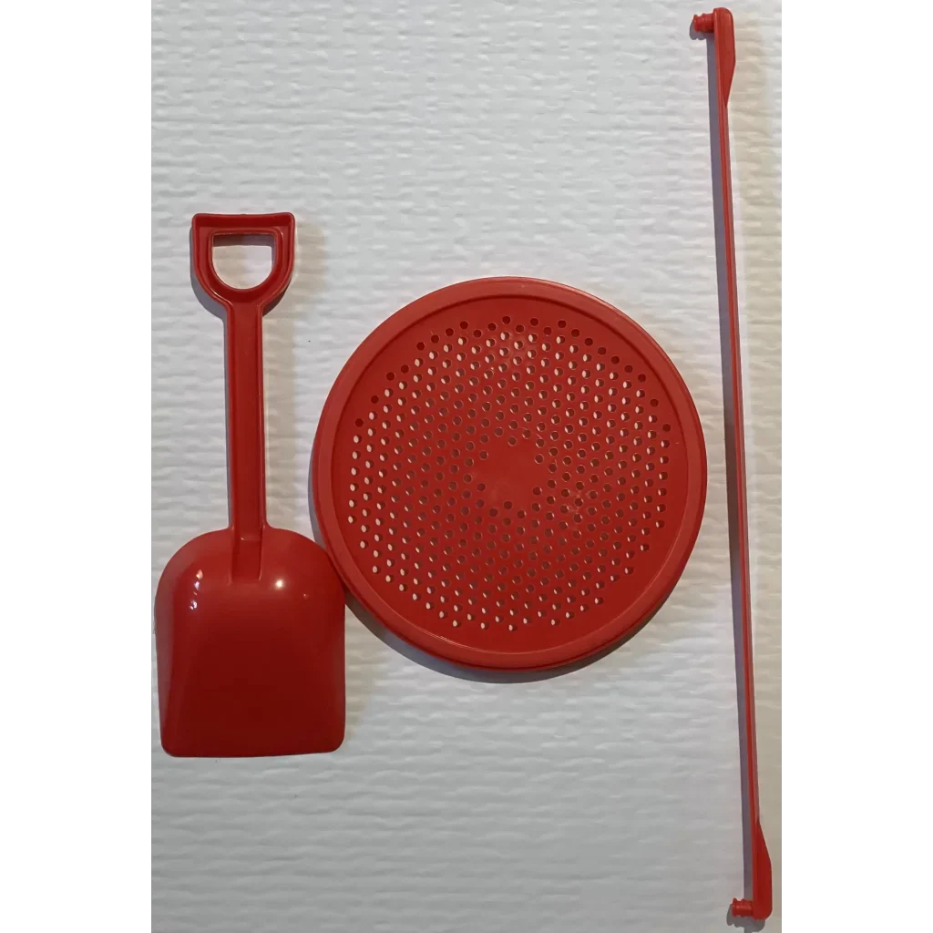 Red plastic sand sifter with shovel and rake for fun summer sandcastle play