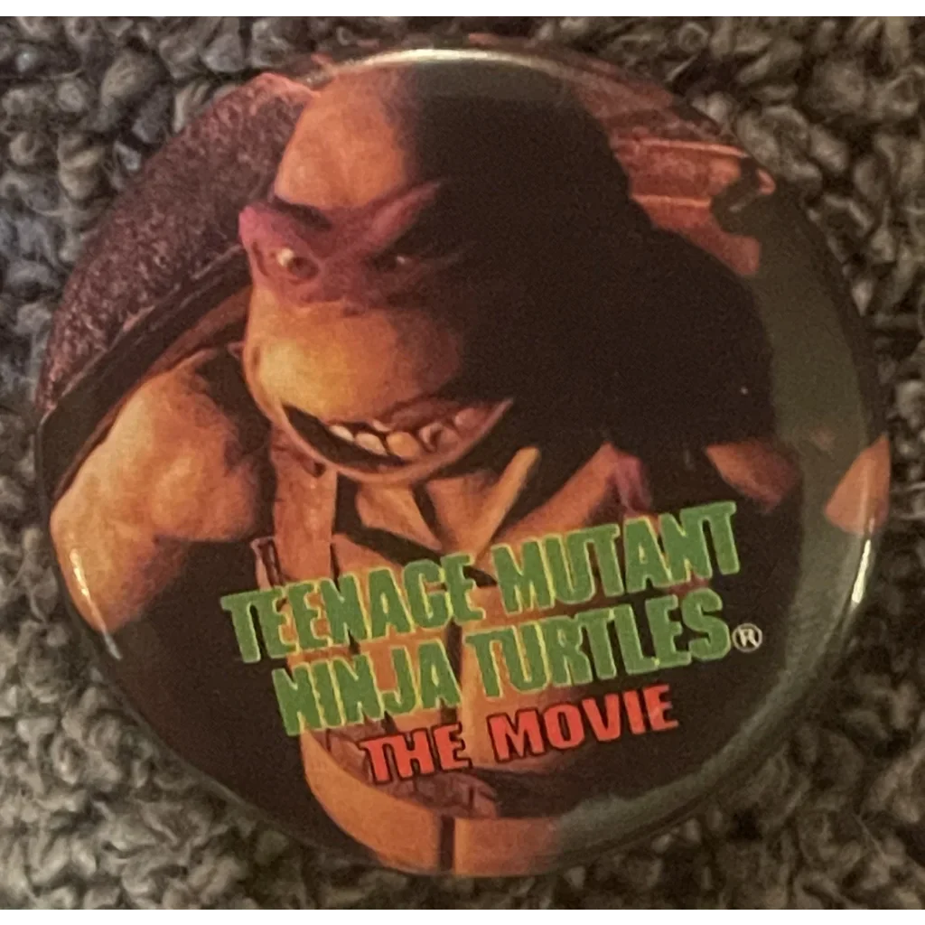 Circular pin showing a Teenage Mutant Ninja Turtle and movie title for collectors