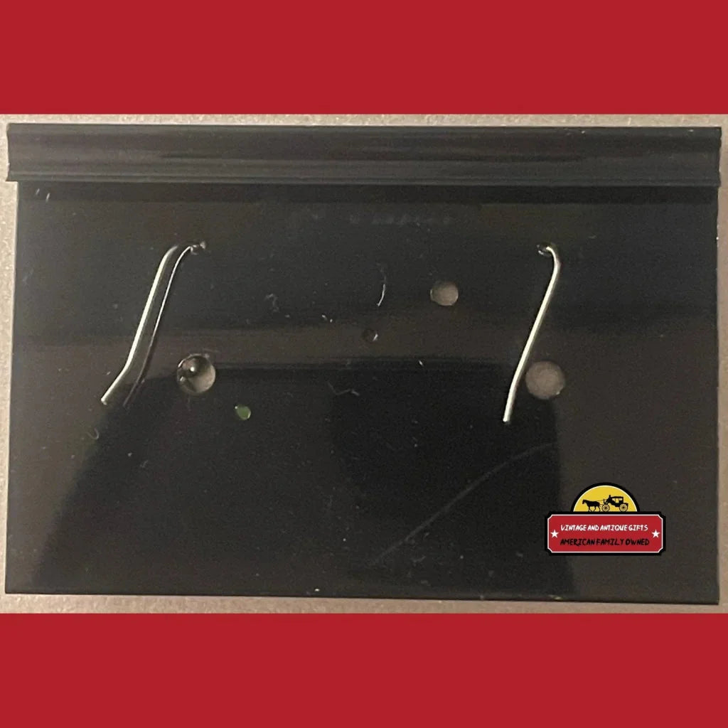 Black metal mailbox with curved handles and yellow sticker next to NKOTB red block earrings