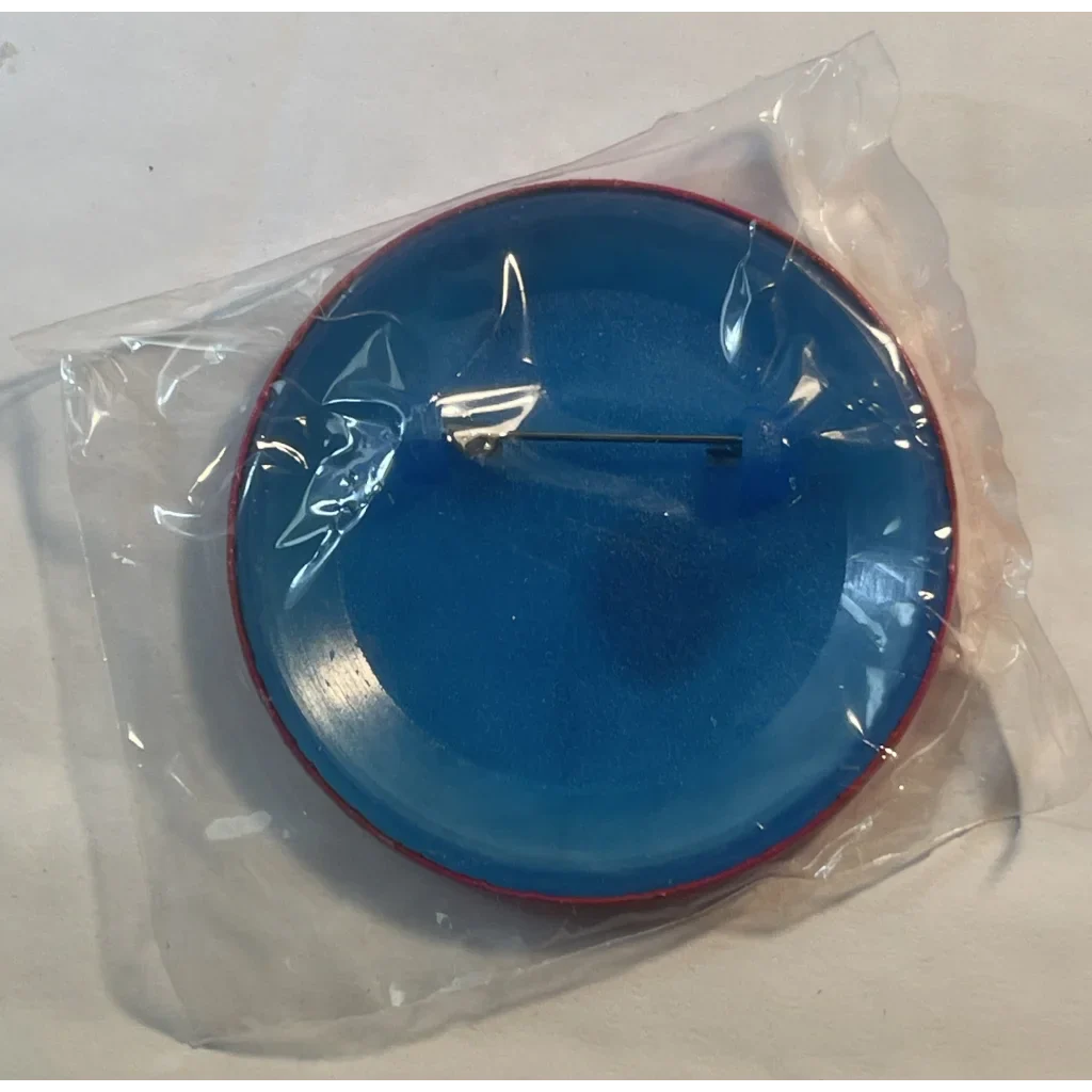 Blue clock face with white hands in plastic wrapper next to Rare 1995 Looney Tunes Pin