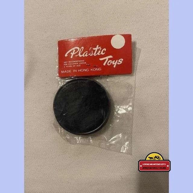 Black plastic disc in clear packaging labeled Plastic Toys for Nostalgic 1950s puzzle game