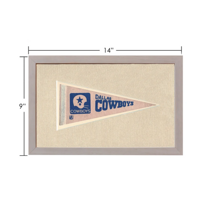 Vintage Dallas Cowboys pennant in frame with beige background