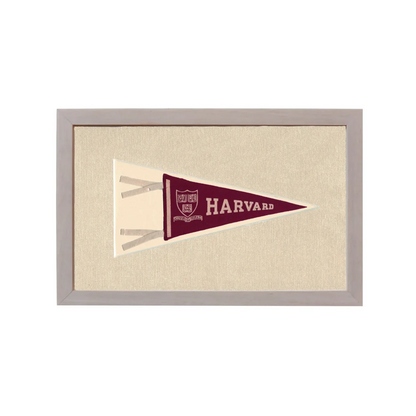 Vintage Harvard pennant in maroon with white lettering and crest, framed