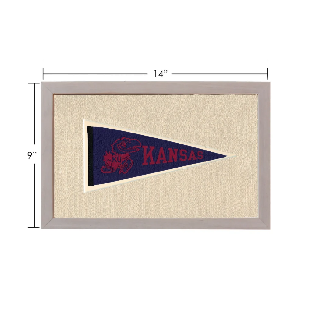 Vintage Kansas pennant in navy blue with red embroidered text and mascot, framed