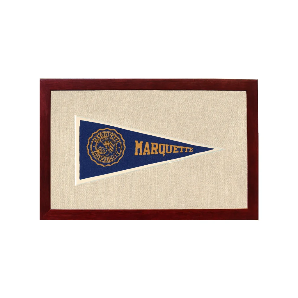 A navy blue vintage marquette university pennant with gold lettering and emblem in a wooden frame