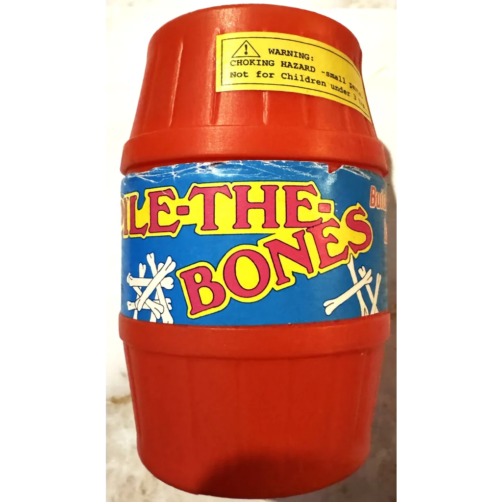 Red plastic container labeled Pile-The-Bones with warning sticker for fun game nights