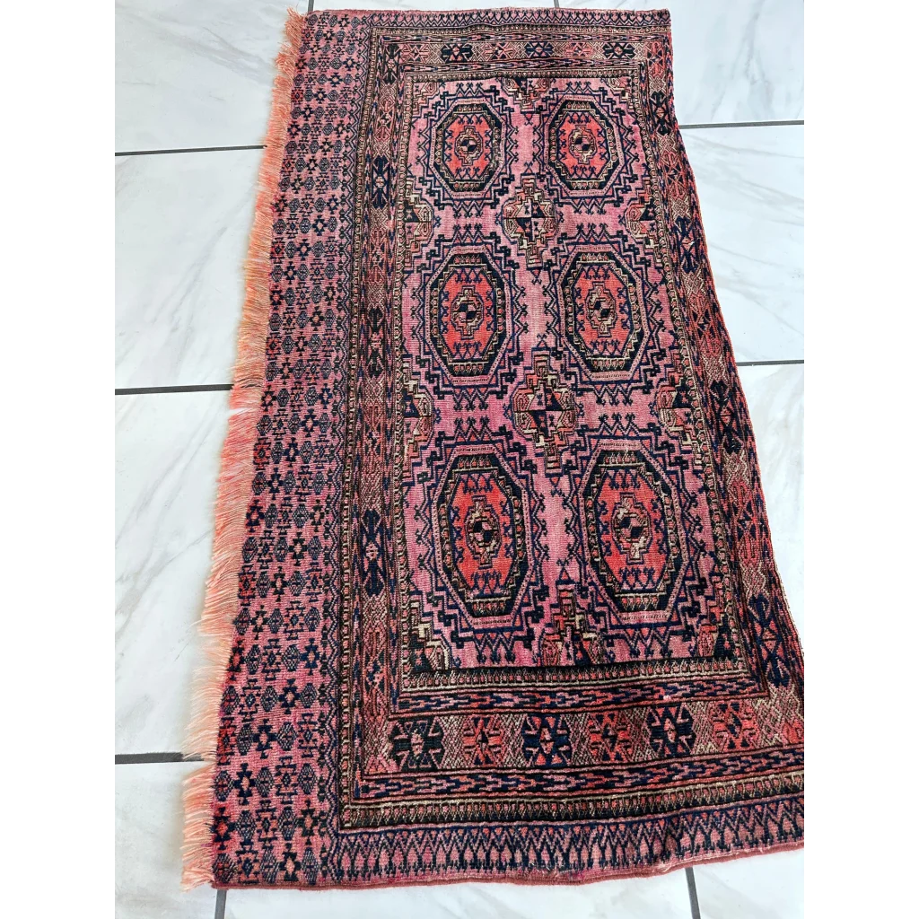 Vintage pink geometric rug with black pattern, fringed edges, MLB career set break ready