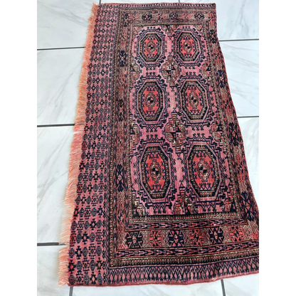 Vintage pink geometric rug with black pattern, fringed edges, MLB career set break ready