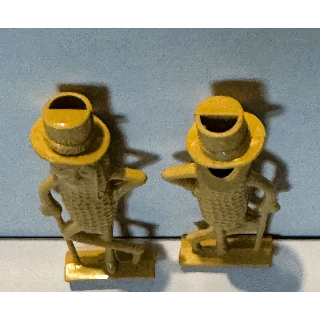 1950s Mr. Peanut whistle collectible: yellow cast iron figurines with hats and cane