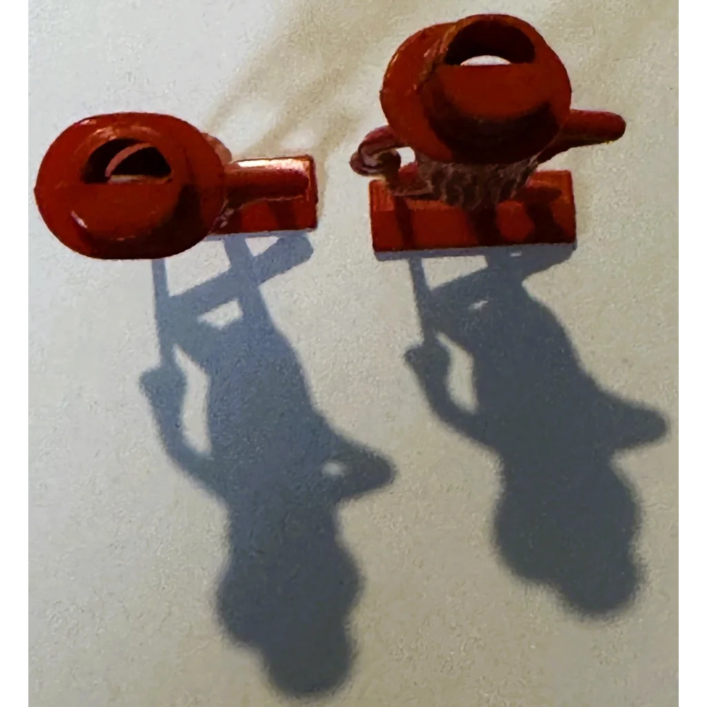 Red plastic toy clamps on vintage 1950s peanut whistle collectible
