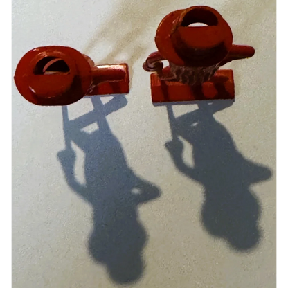 Red plastic toy clamps on vintage 1950s peanut whistle collectible