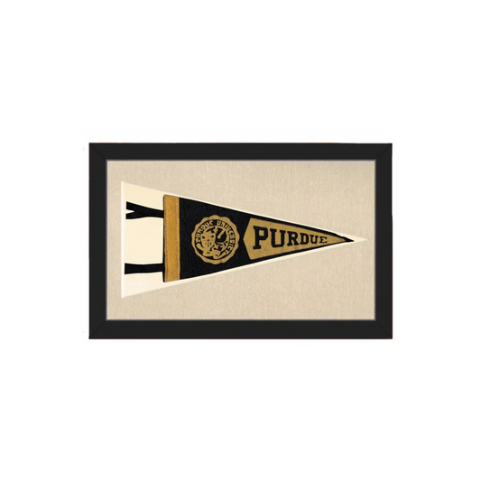 A framed vintage Purdue pennant with black and gold design featuring the school logo on textured fabric background