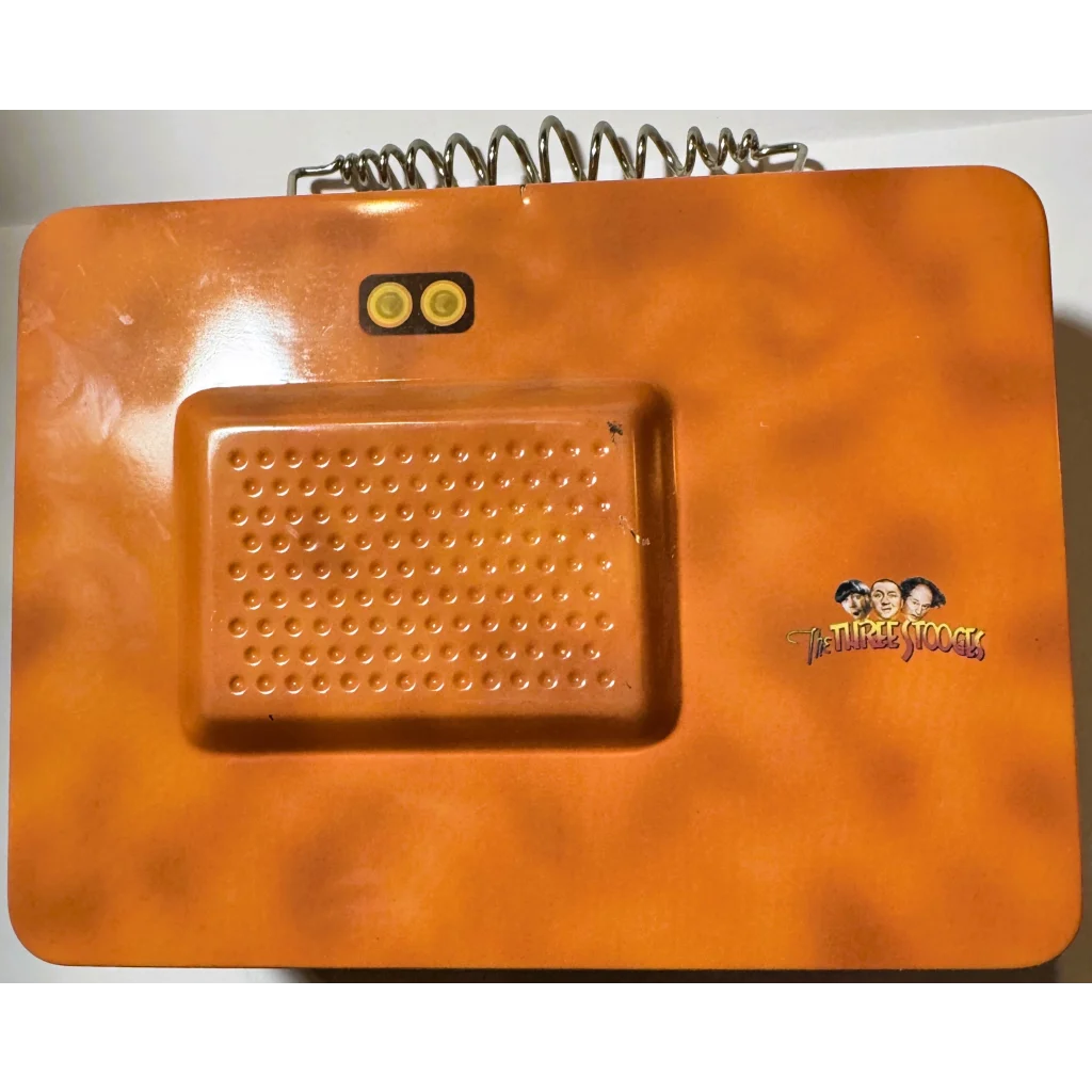 Orange vintage toy telephone with spring cord, part of the Three Stooges lunch box collection