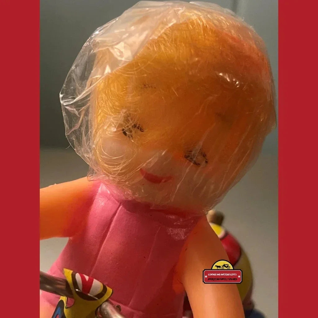 Plastic doll with orange hair in pink outfit, part of Nostalgic Vintage Tin Wind Up toy