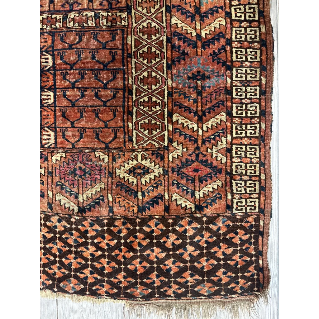 Antique Turkmen Ensi rug with tribal geometric patterns in rust, navy and cream natural wool