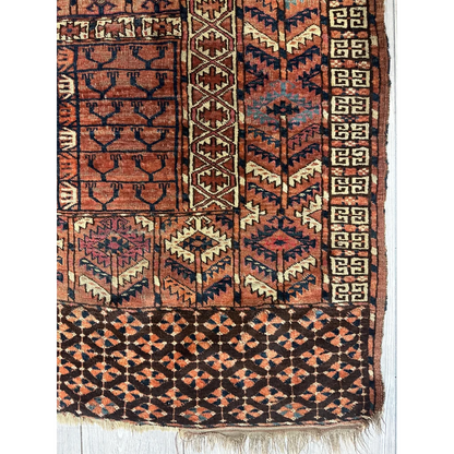 Antique Turkmen Ensi rug with tribal geometric patterns in rust, navy and cream natural wool