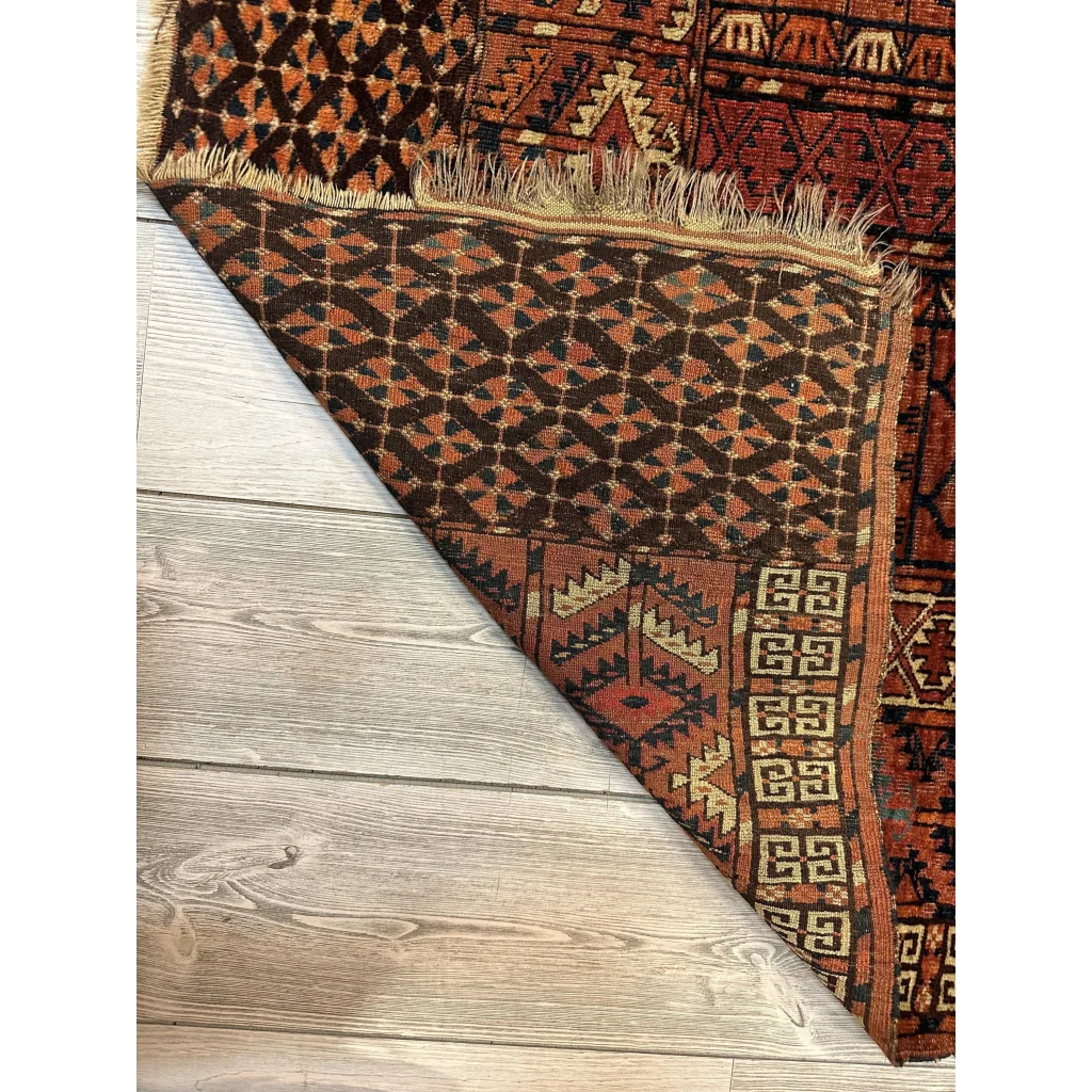Vintage Turkmen geometric rug in rich earthy tones with fringe