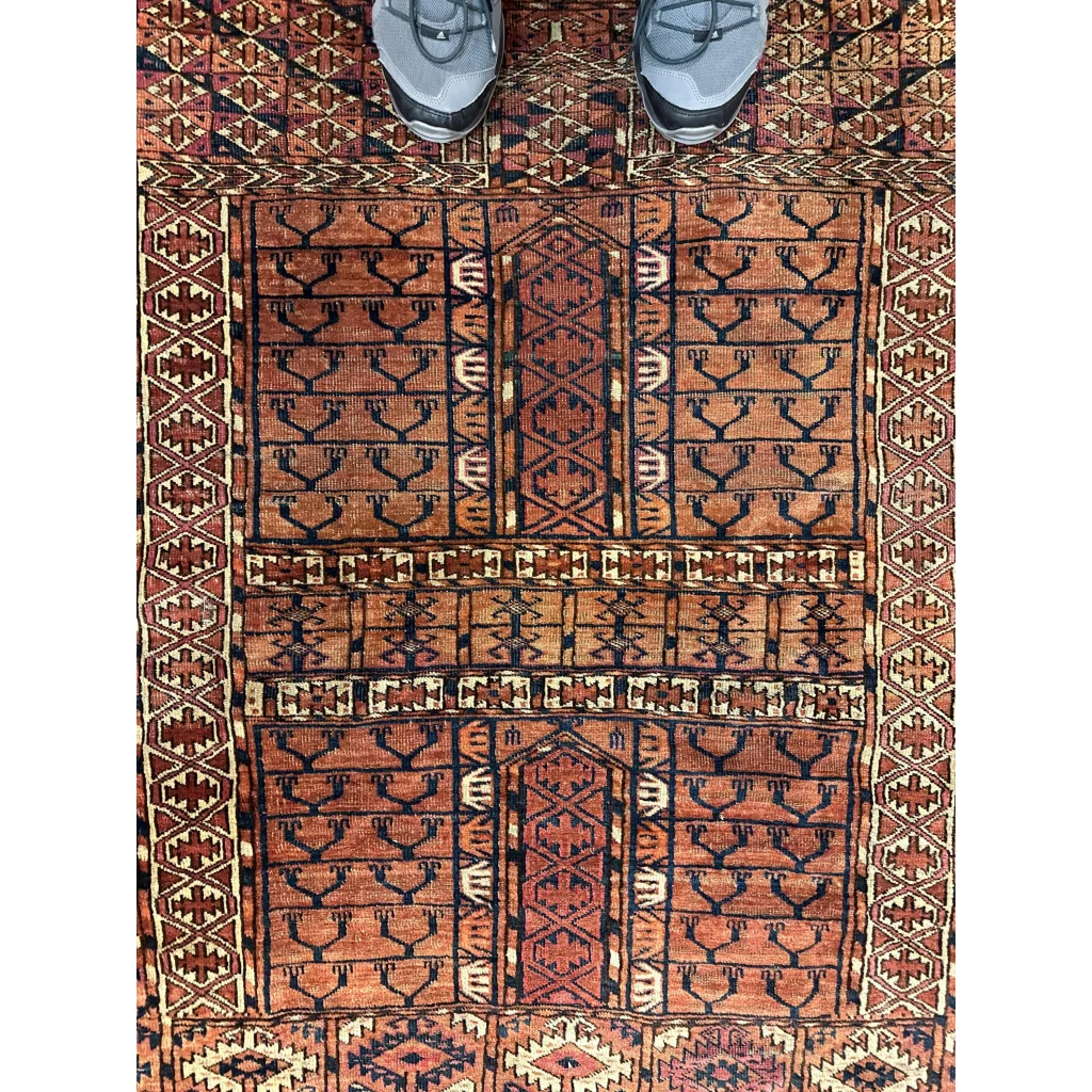 Antique Turkmen Ensi rug with geometric tribal patterns in rust, black and cream