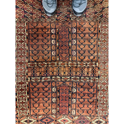 Antique Turkmen Ensi rug with geometric tribal patterns in rust, black and cream