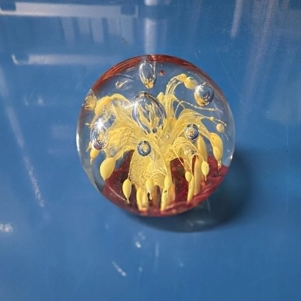 Vtg art glass oval paperweight with yellow floral design and red base