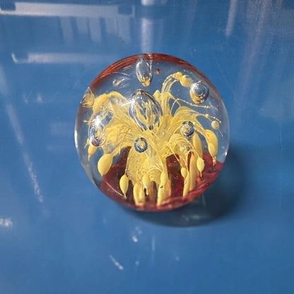 Vtg art glass oval paperweight with yellow floral design and red base