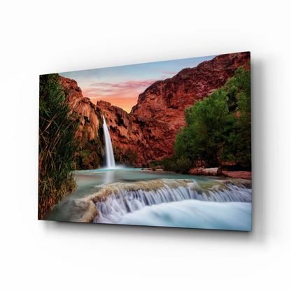 Vibrant waterfall glass wall art cascading through red canyon cliffs at sunset