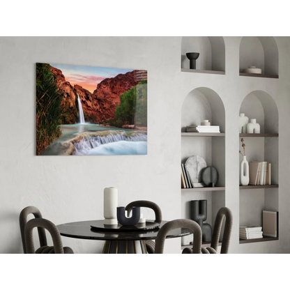 Vibrant glass wall art of waterfall cascading through red canyon cliffs at sunset