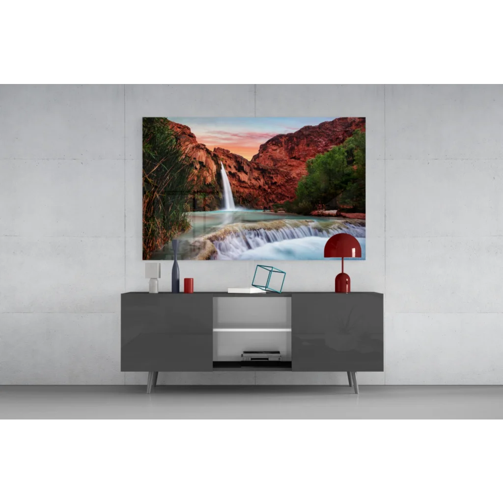 Vibrant glass wall art of waterfall cascading over red canyon cliffs